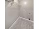 Small laundry area featuring tile flooring, wire shelving, and utility connections at 8270 Mossybrook Ln, Douglasville, GA 30135