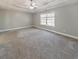 Spacious main bedroom featuring a tray ceiling, carpeted floors, and neutral paint at 8270 Mossybrook Ln, Douglasville, GA 30135