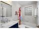 Cozy bathroom features a marble vanity, glass block window, and tub with shower at 3495 Habersham Nw Rd, Atlanta, GA 30305