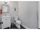 Bright half bathroom featuring black floors, a white vanity, and modern fixtures at 3495 Habersham Nw Rd, Atlanta, GA 30305