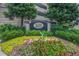 Community sign with flowers, shrubs, and greenery in front of condominium building at 1280 W Peachtree Nw St # 2813, Atlanta, GA 30309