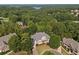 Aerial view of home nestled among lush greenery, with a glimpse of a lake in the distance at 149 Cedar Woods Trl, Canton, GA 30114