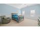 Light blue bedroom with a twin bed, wainscotting, neutral carpet and chair in the corner at 149 Cedar Woods Trl, Canton, GA 30114