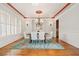 Formal dining room boasts natural light, elegant chandelier, wainscoting and a large area rug at 149 Cedar Woods Trl, Canton, GA 30114