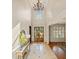 Bright and airy foyer featuring marble floors, wainscoting, and an elegant chandelier at 149 Cedar Woods Trl, Canton, GA 30114