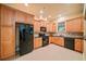 Well-lit kitchen with wooden cabinets, black appliances, granite countertops, and tile flooring at 149 Cedar Woods Trl, Canton, GA 30114