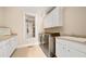 Well-equipped laundry room with modern washer and dryer, ample cabinet space, and a window for natural light at 149 Cedar Woods Trl, Canton, GA 30114