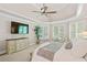 This main bedroom features a tray ceiling, plush carpet, and a wall-mounted television with natural light from the windows at 149 Cedar Woods Trl, Canton, GA 30114