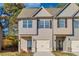 Two story townhome with beige siding, black shutters, and a two-car garage at 2800 Lillian Ln, Douglasville, GA 30135