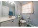 Well-lit bathroom featuring a vanity, toilet, and decorative window at 6432 Phillips Pl, Lithonia, GA 30058