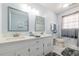 Bright bathroom featuring double vanity, white cabinets, and modern fixtures at 6432 Phillips Pl, Lithonia, GA 30058