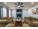 Spacious living room featuring a fireplace, comfortable sofas, and a modern ceiling fan at 6432 Phillips Pl, Lithonia, GA 30058