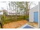 Fenced backyard with fallen leaves on a concrete patio with geometric rug next to a door at 1023 Thornwoode Ln, Stone Mountain, GA 30083