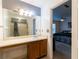 Bathroom vanity with a large mirror, a single sink, wood cabinets, and view to bedroom at 1023 Thornwoode Ln, Stone Mountain, GA 30083