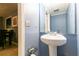 Powder room featuring pedestal sink, framed mirror, and blue paint at 1023 Thornwoode Ln, Stone Mountain, GA 30083