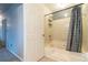 Bathroom showcasing a shower-tub combo with tile surround, gray shower curtain and a white door at 1023 Thornwoode Ln, Stone Mountain, GA 30083