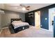 Dark bedroom featuring a queen size bed, ceiling fan, wall shelving, and a doorway to the attached bathroom at 1023 Thornwoode Ln, Stone Mountain, GA 30083