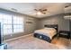 Bedroom featuring a window, wall shelving, ceiling fan, and queen bed with carpet flooring at 1023 Thornwoode Ln, Stone Mountain, GA 30083