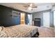 Bedroom featuring wall shelving, ceiling fan, queen bed, as well as a doorway to the attached bathroom at 1023 Thornwoode Ln, Stone Mountain, GA 30083