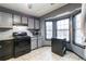 Well lit kitchen with grey cabinets, stainless appliances and tile flooring at 1023 Thornwoode Ln, Stone Mountain, GA 30083