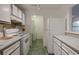 White appliances and grey cabinets in this galley kitchen at 1414 Branch Dr, Tucker, GA 30084