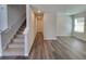 Living room with stairs, wood-look flooring, and a view to the kitchen at 15 Heyman Dr, Covington, GA 30016