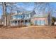 Two-story house with brick and siding, blue shutters, and a covered porch at 1491 Laurel River Trl, Lawrenceville, GA 30043