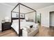 Bright bedroom features a four-poster bed, hardwood floors, and ensuite bathroom at 412 Southbridge Pass, Peachtree City, GA 30269