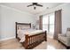 A cozy bedroom with a wooden bed frame, ceiling fan, and window with blinds at 412 Southbridge Pass, Peachtree City, GA 30269