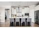 Bright kitchen boasts white cabinets, subway tile backsplash, stainless appliances, and seating for four at island at 412 Southbridge Pass, Peachtree City, GA 30269