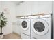 Well-lit laundry room equipped with modern, front-load washer and dryer at 412 Southbridge Pass, Peachtree City, GA 30269