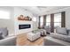 Cozy living room featuring a fireplace, neutral furniture, and lots of natural light at 412 Southbridge Pass, Peachtree City, GA 30269