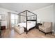 Bright main bedroom with a four-poster bed, hardwood floors, and neutral decor at 412 Southbridge Pass, Peachtree City, GA 30269
