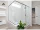 Modern bathroom features a glass shower enclosure with white tile, accented by minimalist floating shelves at 412 Southbridge Pass, Peachtree City, GA 30269