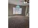 Spacious living room featuring a large window, carpeted floors, and a ceiling fan at 10561 Aspenwood Ct, Jonesboro, GA 30238