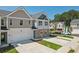 Two-story townhome with gray and beige siding, brick accents, and a two-car garage at 327 Crimson Dr, Union City, GA 30291
