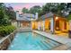 Backyard pool with a stone waterfall feature and a covered outdoor lounge area at dusk at 2522 Habersham Nw Rd, Atlanta, GA 30305