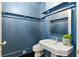 Stylish powder room with a pedestal sink, dark blue walls, and modern fixtures at 2522 Habersham Nw Rd, Atlanta, GA 30305