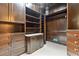 Walk-in closet featuring dark wood built-in shelving units, cabinets with marble countertop and carpeted flooring at 2522 Habersham Nw Rd, Atlanta, GA 30305