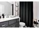 Clean bathroom with dark vanity, white toilet, and black shower curtain at 510 Oak Dr, Hapeville, GA 30354