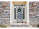 Elegant front door with stone surround and glass accents at 1354 Benbrooke Nw Ln, Acworth, GA 30101