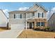 Two-story house with gray siding, stone accents, and a two-car garage at 251 Ivy Chase Loop, Dallas, GA 30157