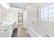 Bathroom with double vanity, tub, and window at 2650 Hamilton Chase Run, Buford, GA 30519