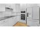 Modern white kitchen with stainless steel appliances, granite countertops and ample storage at 211 Colonial Homes Nw Dr # 1105, Atlanta, GA 30309