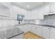 A well-lit kitchen with granite countertops and white cabinets at 211 Colonial Homes Nw Dr # 1105, Atlanta, GA 30309