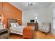 Bedroom with orange accent wall, hardwood floors, and comfortable seating at 6229 Grand Loop Rd, Sugar Hill, GA 30518