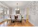 Bright dining room with a large table, chandelier, and decorative wallpaper at 6229 Grand Loop Rd, Sugar Hill, GA 30518