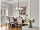 Elegant dining room features a formal table, chandelier, and decorative wallpaper at 6229 Grand Loop Rd, Sugar Hill, GA 30518