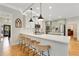 Modern kitchen featuring white and green cabinets, quartz countertops, and breakfast bar at 6229 Grand Loop Rd, Sugar Hill, GA 30518