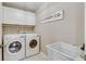 Bright laundry room with washer, dryer, and utility sink at 6229 Grand Loop Rd, Sugar Hill, GA 30518